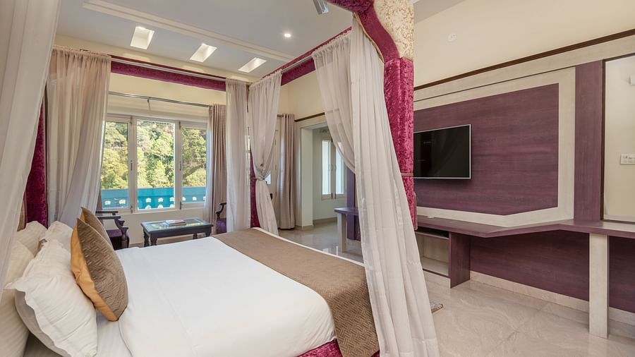 Luxurious bedroom at DLS Tehri Club Resort with a four-poster bed and elegant decor.